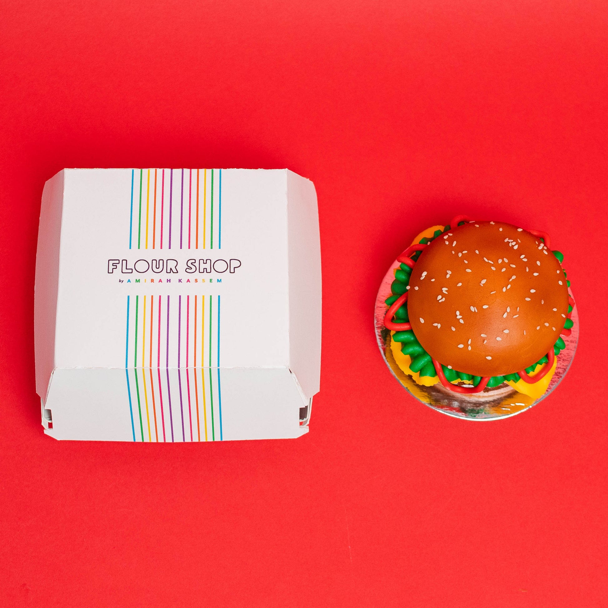 Small and large vanilla cake that is decorated to look like a cheese burger