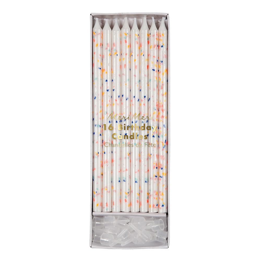 24 tall white candles decorated with muticolored neon flecks and candle holders