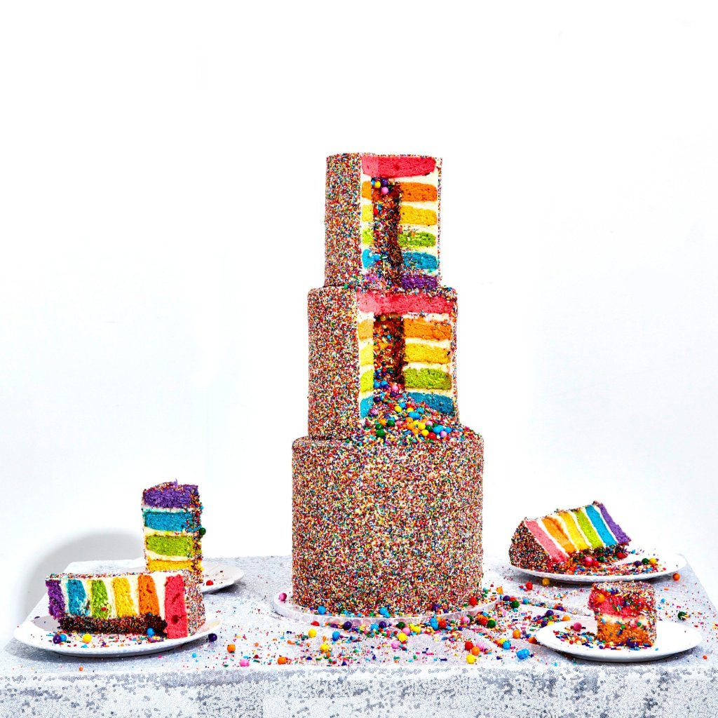 3 tiered cake. Each cake has 6 rainbow layers, cream cheese frosting, decorated with nonpareils and contain a sprinkle surprise in the center.