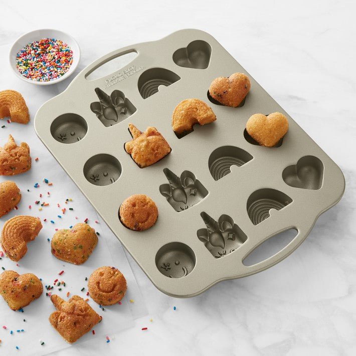 Cast-aluminum pan with 16 cake bites: 4 smiley faces, 4 unicorns, 4 rainbows and 4 hearts
